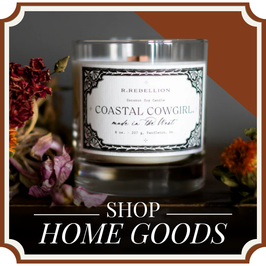 Candle with a label on a surface surrounded by flowers, with text 'Shop Home Goods' and 'Coastal Cowgirl' branding. | Crooked Horn Company | San Tan Valley, AZ